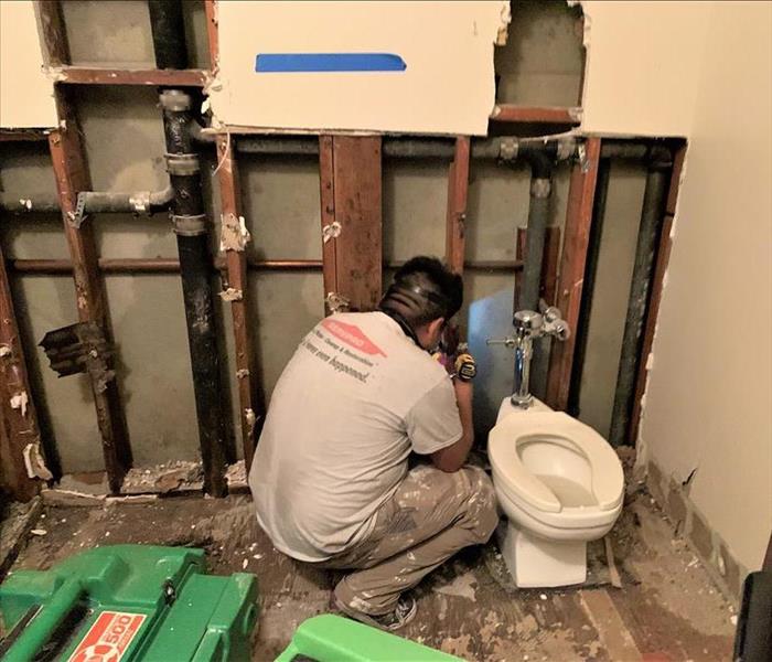 Technician working in a water damaged bathroom of a commercial job. 